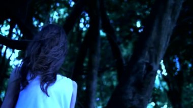 Uzun siyah yüz saçlı bir Cadılar Bayramı hayalet kız kalın bir korkunç ormanda duruyor. Close