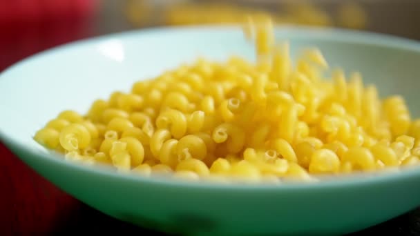 Rauwe pasta. kawatappi pasta valt in een blauwe schotel — Stockvideo