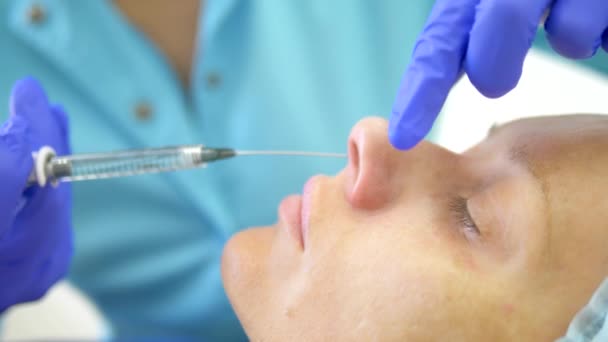 화장품 개념. 코 윤곽 보정. 의사 미용사가 환자 여성의 코에 필러를 주입합니다. 클로즈업 — 비디오