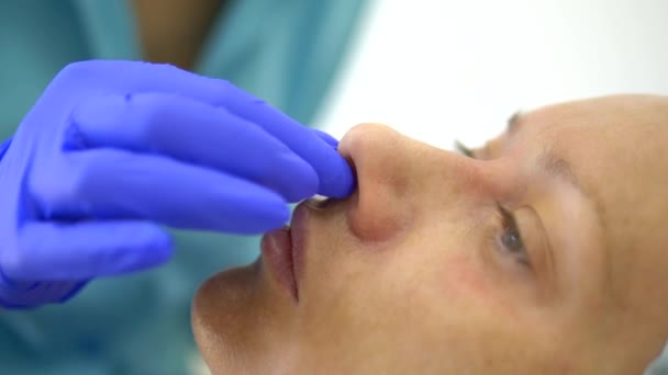 Koncepcja kosmetyczna. Korekta konturu nosa. Kosmetyczka prowadzi prace przygotowawcze do procedury konturowania nosa pacjentki. Zbliżenie — Wideo stockowe