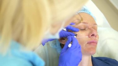 kontur plastik yüz kavramı. Plastik cerrahlar el bir kalem ile kadın yüzüne konturlar çizer. Close