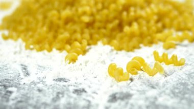 pişmemiş makarna. Close. Cavatappi makarna ahşap bir masa üzerinde beyaz un yatıyor
