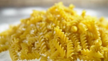 ham makarna fusilli, ahşap bir masa üzerinde beyaz un yalan closeup.