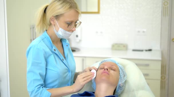 Косметична концепція. Корекція контуру носа. Косметолог проводить підготовчі роботи по процедурі контурування носа пацієнта жінки. крупним планом — стокове відео