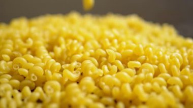 çiğ makarna. makarna Cavatappi ahşap bir masaya düşen