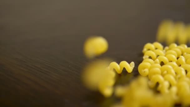 Raw pasta. pasta Cavatappi falling on a wooden table — Stock Video