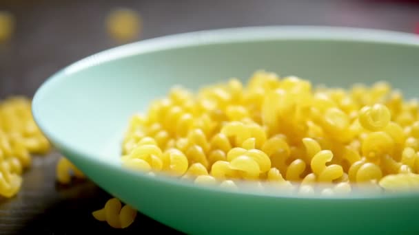 Pasta cruda. pasta kawatappi cae en un plato azul — Vídeo de stock