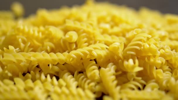 Pasta cruda. Fusilli, el primer plano cae sobre una mesa de madera , — Vídeo de stock