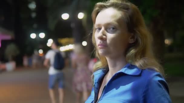 Retrato de una mujer triste y solitaria en el fondo de la calle nocturna. iluminación nocturna — Vídeos de Stock