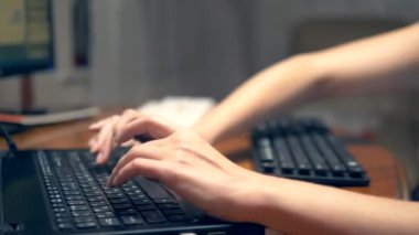 Sosyal ağlarda çoklu görev veya hile kavramı. Bir kadın aynı anda üç klavye de tipleri. el closeup.