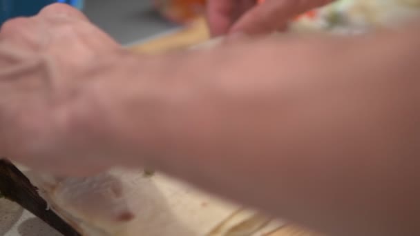 Cierra las manos. Un hombre prepara shawarma en la mesa de la cocina en casa — Vídeo de stock