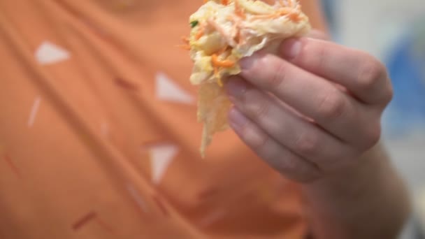 Close-up. Um homem come shawarma em casa na cozinha — Vídeo de Stock