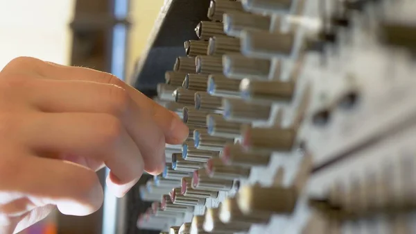 close-up. Hand Turns the pan knob on the sound mixer