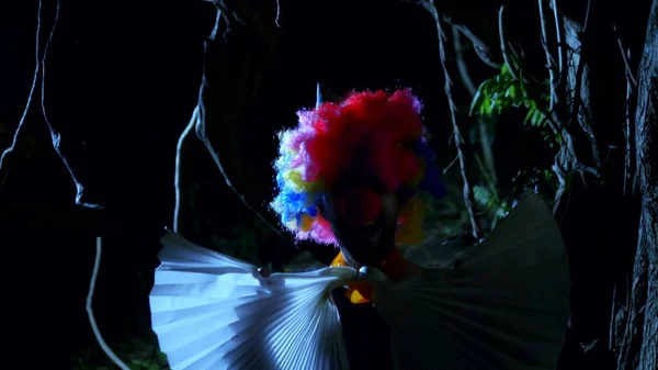 Halloween, clown maléfique avec un arc autour du cou dans une terrible forêt sombre la nuit. éclairs — Photo