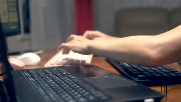 Das Konzept von Multitasking oder Schummeln in sozialen Netzwerken. Eine Frau tippt gleichzeitig auf drei Tastaturen. Nahaufnahme mit der Hand. — Stockvideo