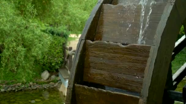 Wassermühle. Nahaufnahme. die Details. Das hölzerne Mühlrad dreht sich unter dem Wasserstrom — Stockvideo