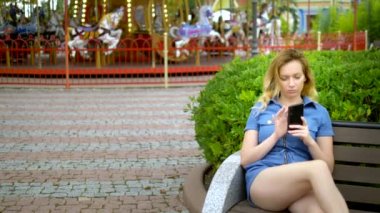 Genç kadın eğlence parkında Smartphone kullanır. Freelancer kavramı, uzaktan çalışır
