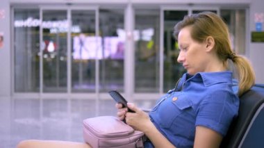 akıllı telefon kullanarak havaalanı bekleme alanında kız. seyahat konsepti