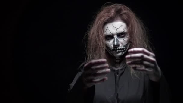 Concept, beau maquillage pour Halloween. Portrait d'une jeune fille sexy avec du maquillage de crâne. sur fond noir, visage dans le noir. gros plan — Video