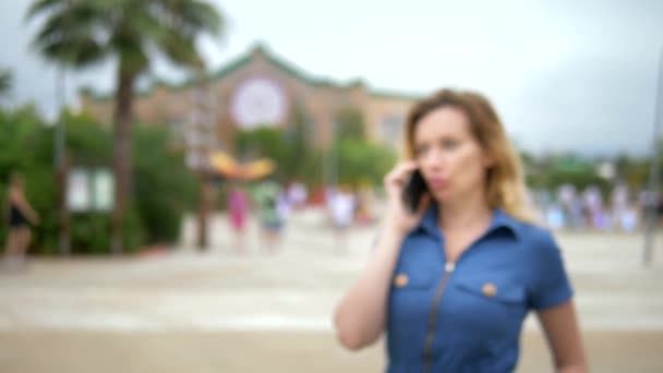 Primo piano. Una giovane donna preoccupata che parla al telefono. all'aperto — Video Stock