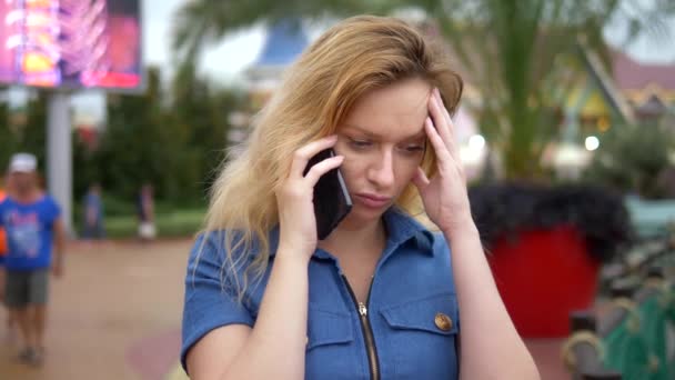 Närbild. orolig ung kvinna pratar i telefon. Utomhus — Stockvideo