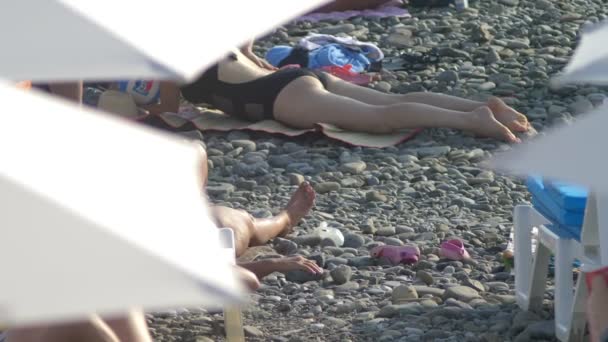 Fondo borroso. sillas de playa y sombrillas en la playa, personas irreconocibles descansando — Vídeos de Stock