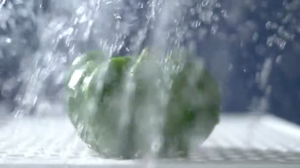 Γλυκό πράσινο πιπέρι σε ένα σκοτεινό φόντο στο στούντιο κάτω από πίδακες βροχής. — Αρχείο Βίντεο