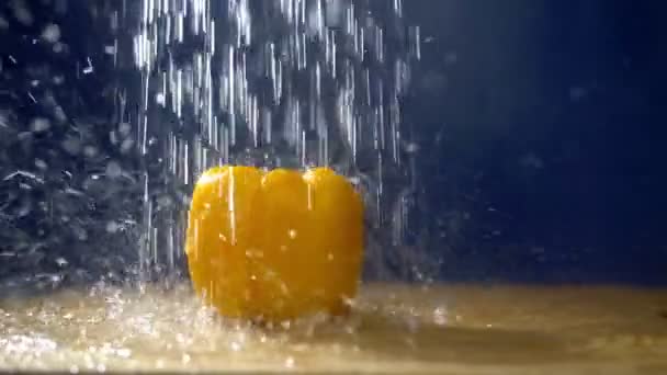 Poivron jaune doux sur un fond sombre dans le studio sous des jets de pluie . — Video