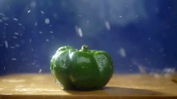 Zoete groene peper op een donkere achtergrond in de studio onder straal van regen. — Stockvideo