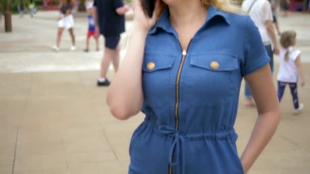 Close-up. bezorgde jonge vrouw die aan de telefoon praat. Outdoor — Stockvideo