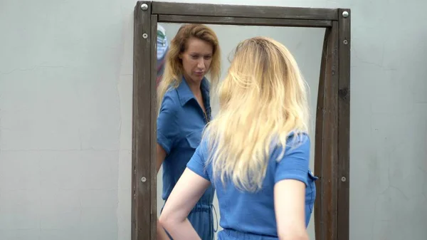 Křivá zrcadla. mladá štíhlá žena se dívá v křivém zrcadle s úsměvem. — Stock fotografie