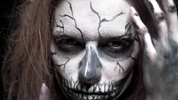 Concept, beautiful makeup for halloween. Portrait of a young sexy girl with skull makeup. on a black background, face in the dark. close-up — Stock Photo, Image