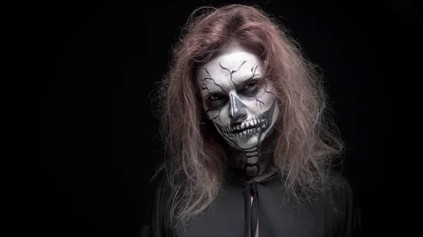 Konzept, schönes Make-up für Halloween. Porträt eines jungen sexy Mädchens mit Totenkopf-Make-up. auf schwarzem Hintergrund, Gesicht im Dunkeln. Nahaufnahme — Stockfoto