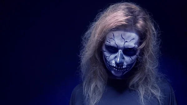 Koncept, vacker makeup för Halloween. Porträtt av en ung sexig tjej med skalle makeup. på en svart bakgrund, ansikte i mörkret. Närbild — Stockfoto