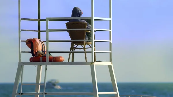 Un salvavidas irreconocible en una torre de rescate en la playa. concepto de seguridad marítima — Foto de Stock