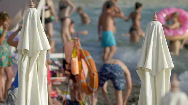 Sfondo sfocato. sdraio e ombrelloni in spiaggia, persone irriconoscibili che riposano — Foto Stock