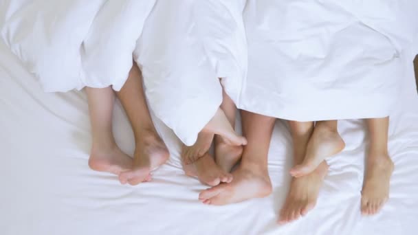 개념 섹스 클럽, 스윙 클럽, 라이프 스타일 클럽, 공식, 비공식 그룹. 킹 사이즈 침대에 흰색 시트에 흰색 담요 아래 사람들의 그룹의 발 — 비디오