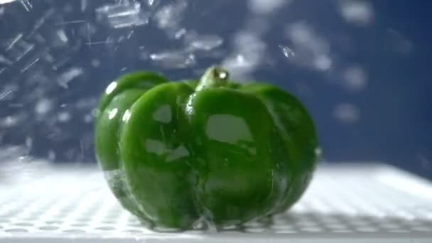 Γλυκό πράσινο πιπέρι σε ένα σκοτεινό φόντο στο στούντιο κάτω από πίδακες βροχής. — Αρχείο Βίντεο