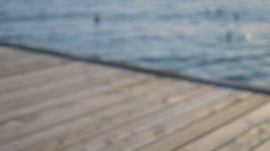 parlak pembe mayo muhteşem göğüsleri ile güzel ince kadın yatıyor ve deniz üzerinde ahşap bir terasta güneşlendi.