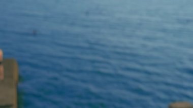 parlak pembe mayo muhteşem göğüsleri ile güzel ince kadın yatıyor ve deniz üzerinde ahşap bir terasta güneşlendi.