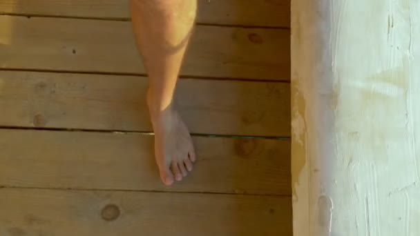 Close-up. mannelijke blote voeten lopen op houten planken. — Stockvideo