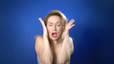 Pin-up kız kavramı. mavi arka plan. kopya alanı. Kadın sürprizi yanakları elle tutar. Etkileyici yüz ifadeleri