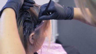 Close. saç boyama konsepti. kuaför renklendirici bir fırça ile bir kadının saç boyası