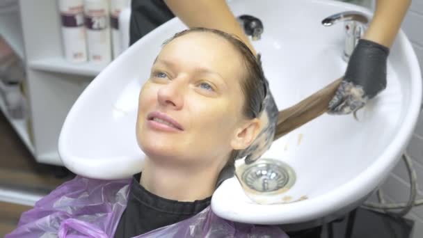 Processus de lavage de vos cheveux dans un coiffeur. fille dans un salon de beauté. laver les cheveux, soin des cheveux, santé . — Video