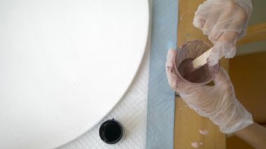 yakın çekim, tek kullanımlık bir fincan boya karıştırma. sanatçılar işyeri. tuval üzerine akrilik boyalar ile çalışmak için iş akışının hazırlanması. sanat sıvısı