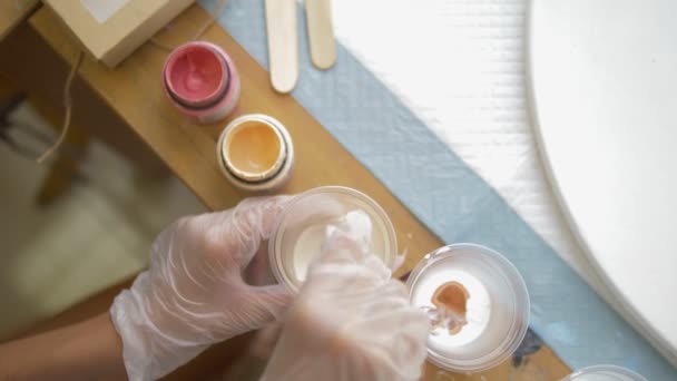 Yakın çekim, tek kullanımlık bir fincan boya karıştırma. sanatçılar işyeri. tuval üzerine akrilik boyalar ile çalışmak için iş akışının hazırlanması. sanat sıvısı — Stok video