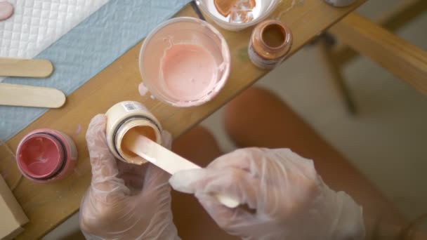 Primer plano, mezclando pintura en una taza desechable. artistas lugar de trabajo. preparación del flujo de trabajo para trabajar con pinturas acrílicas sobre lienzo. arte fluido — Vídeos de Stock