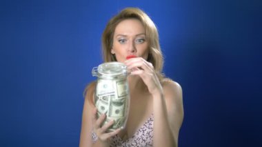 para tasarrufu kavramı. mavi bir arka plan üzerinde dolar dolu bir cam kavanoz tutan pin-up kadın. garip insanların maceralarını. kopyalama alanı