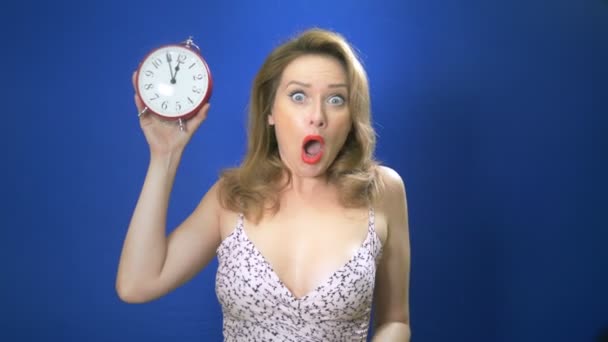 Surprised pin-up woman holding clock. Amazed pinup girl. Saving time concept. Summer sale. Discount. blue background Copy space. Expressive facial expressions. — Stock Video