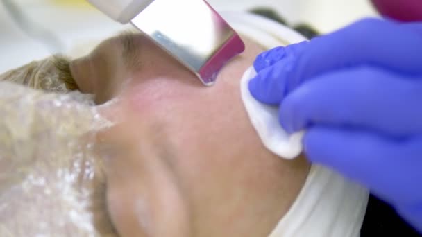 Nahaufnahme. Ultraschall-Gesichtsreinigung. moderne Ausrüstung. Kosmetikerin macht kosmetischen Eingriff im Gesicht der Frau. — Stockvideo